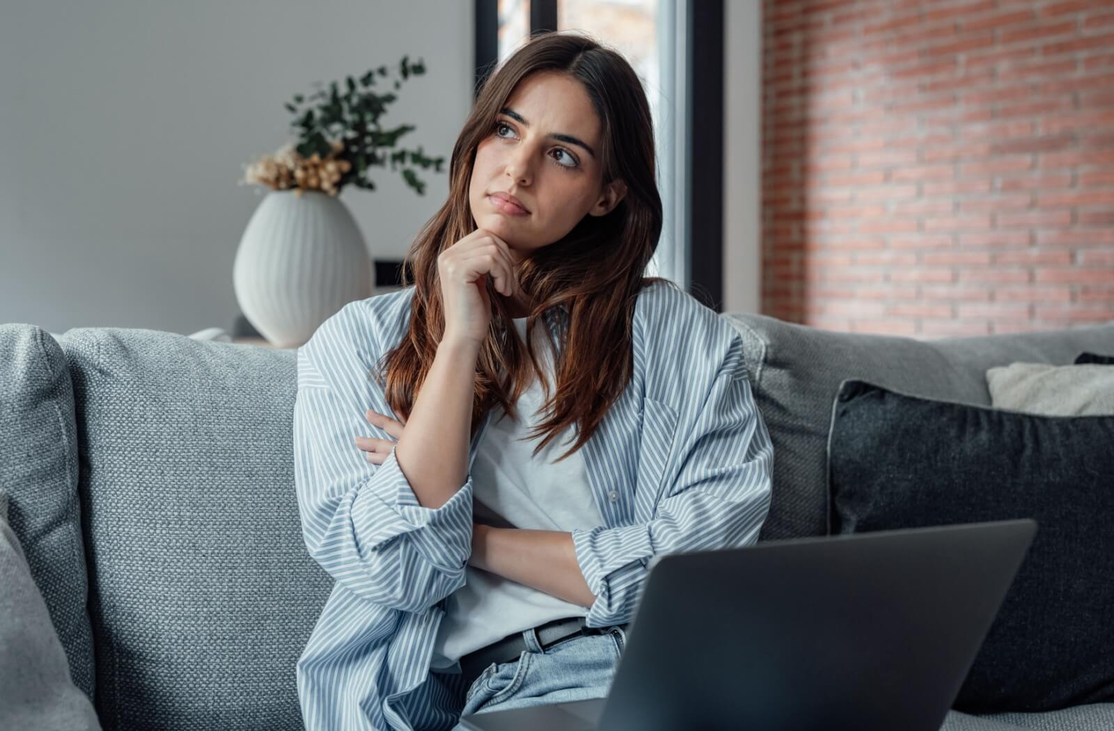 A person on their couch wonders if they might need a root canal, or if there is another treatment choice.